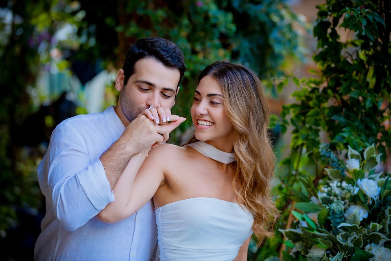 Joe kisses Myriam's hand in a garden